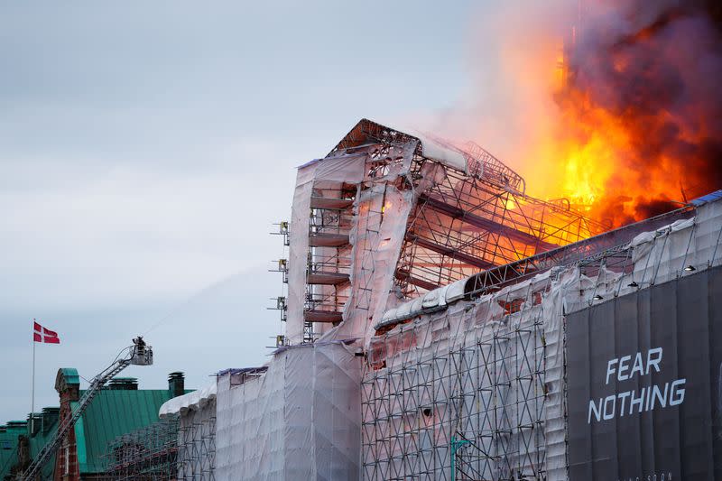 A firefighter works as fire burns at the Old Stock Exchange, Boersen, in Copenhagen