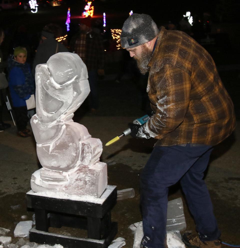 Fred Grosser carves Olaf from "Frozen" in ice on Saturday, Dec. 3, 2022, during Christmas in the Park at Silver Park.