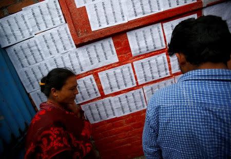 People search for their names from the name list kept outside a polling station for the upcoming local election of municipalities and villages representatives in Bhaktapur, Nepal May 11, 2017. REUTERS/Navesh Chitrakar