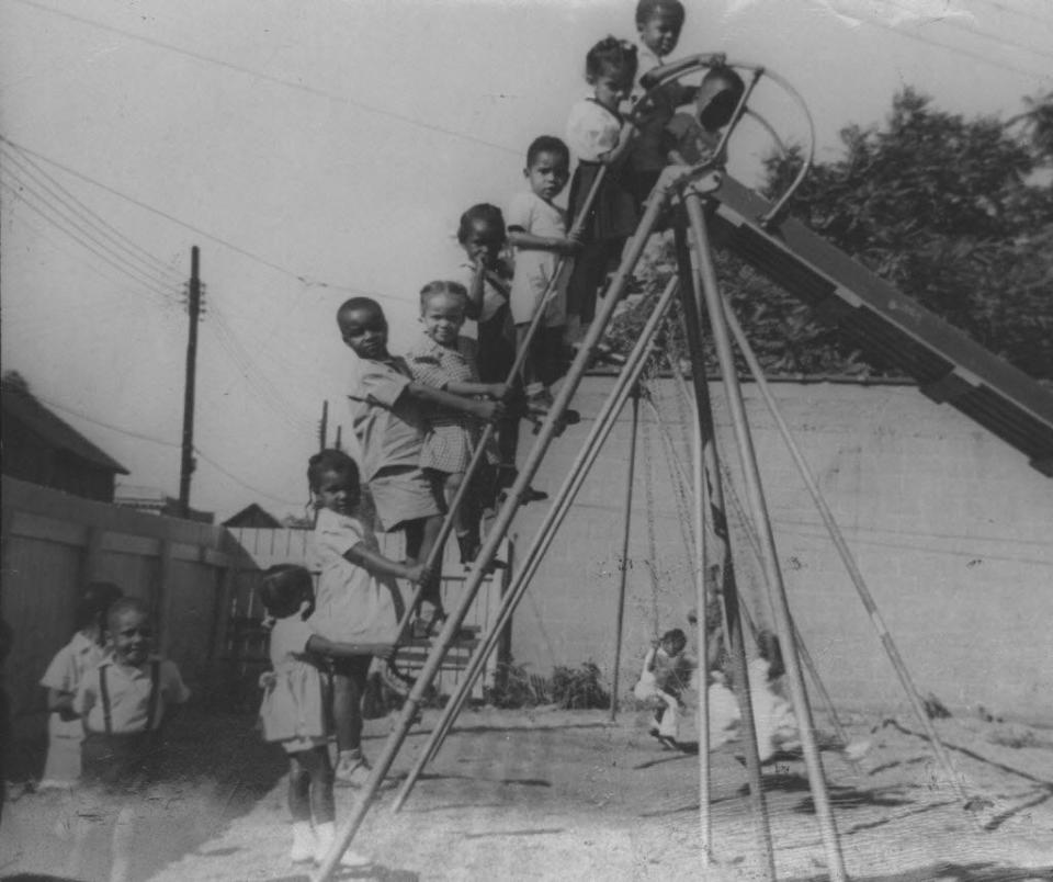 This 1950s photograph shows a youngsters posing on a slide at the Hering House playground. Often referred to as the “House of Hope,” the Hering House served as a center for community activities.