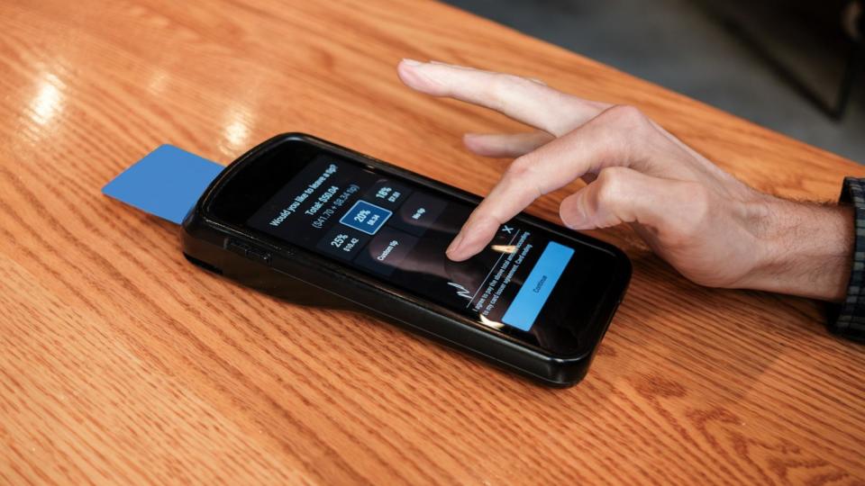 PHOTO: In this undated stock photo, a customer is prompted to select a tip amount on a portable card reader.  (STOCK PHOTO/Getty Images)