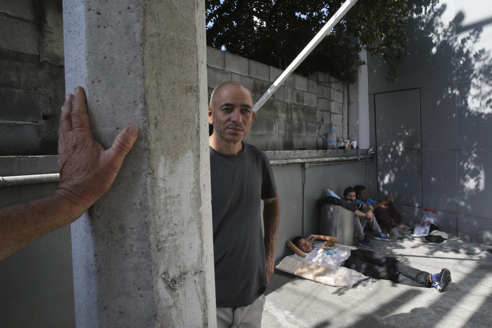 In this July 19, 2019 photo, Honduran migrant Neftali Anael Cantillana, who worked as a teacher in Honduras, who travelled with his 16-year-old son, bed down on a sidewalk in after being bused from Nuevo Laredo to Monterrey, Mexico. The Mexican government says it is analyzing possibilities for setting up makeshift shelters at warehouses and other properties to handle returnees to Nuevo Laredo. Meanwhile "remain in Mexico" has now gone into effect for another Tamaulipas border city: Matamoros, across from Brownsville, Texas. (AP Photo/Marco Ugarte)