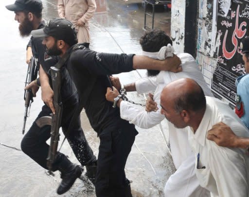 A Pakistani policeman reprimands Islamic cleric Hafiz Mohammed Khalid Chishti after he attempted to shout slogans upon his arrival at a court in Islamabad on September 2. The cleric who accused a young Christian girl of blasphemy in a case that sparked international concern has been remanded in custody on suspicion of evidence-tampering and desecrating the Koran