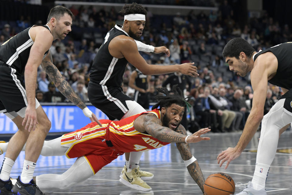 Atlanta Hawks forward Saddiq Bey (41) dives for the ball between Memphis Grizzlies guards John Konchar and Jordan Goodwin and forward Santi Aldama, from left, during the first half of an NBA basketball game Friday, March 8, 2024, in Memphis, Tenn. (AP Photo/Brandon Dill)