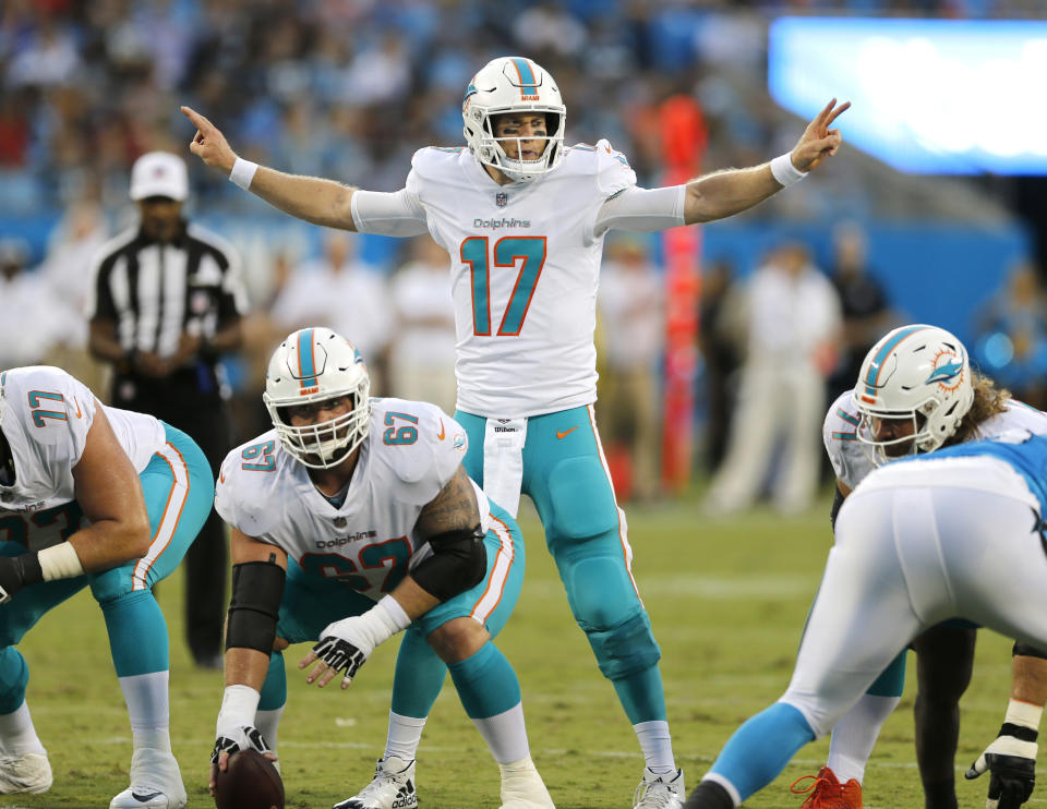 FILE - In this Aug. 17, 2018, file photo, Miami Dolphins' Ryan Tannehill (17) calls a play at the line of scrimmage, behind center Daniel Kilgore (67) in the first half of an NFL football game against the Carolina Panthers, in Charlotte, N.C. Tannehill is back under center for Miami after being sidelined since December 2016 because of two injuries to left knee. The Dolphins are banking on him having a big-time comeback, or at least be better than Jay Cutler was last season while filling in.(AP Photo/Nell Redmond, File)