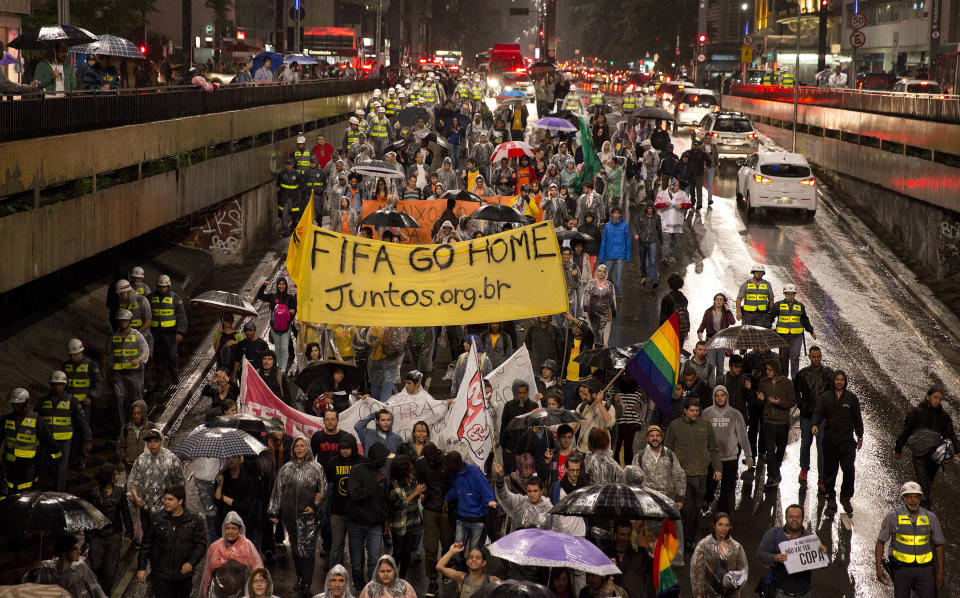 Demonstrators march to protest the amount of money spent on World Cup preparations in Sao Paulo, Brazil, Tuesday, April 15, 2014. Brazil will host the soccer tournament this year. (AP Photo/Andre Penner)