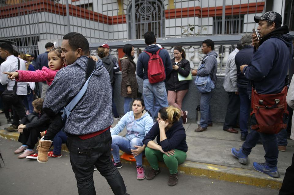 Venezuelans who recently moved to Peru wait outside the Venezuelan embassy to try to get on a list for a government-financed flight home, in Lima, Peru, Tuesday, Sept. 4, 2018. Some of the migrants said they prefer to return because they haven't found work or the working conditions were not what they expected in Peru. (AP Photo/Martin Mejia)