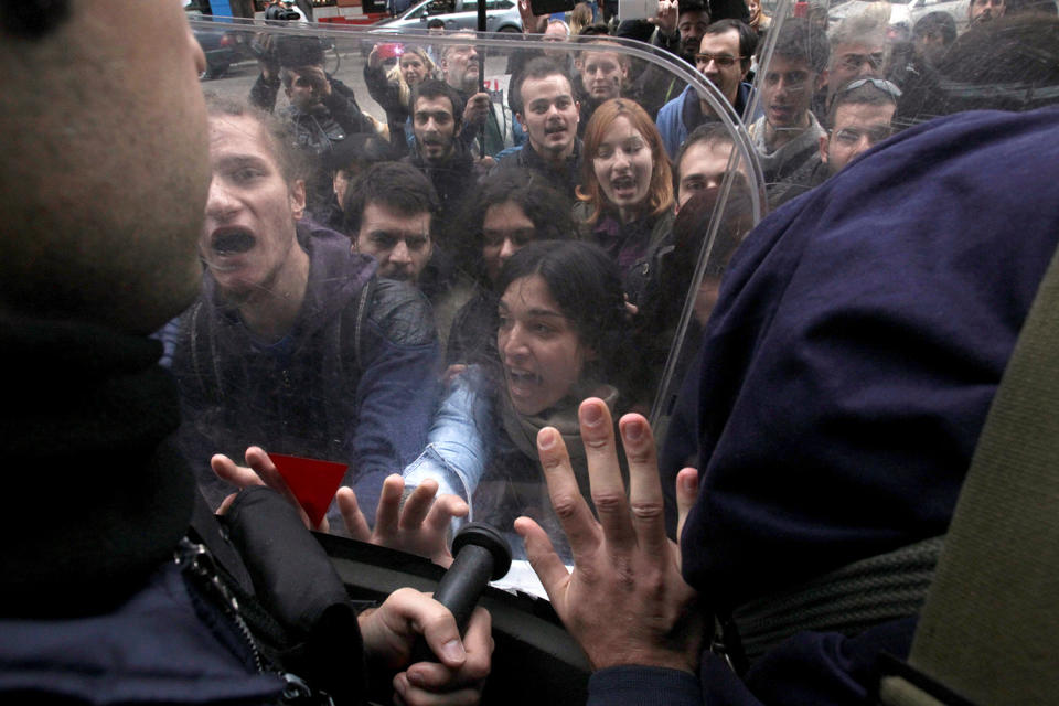 Demonstrators scuffle with riot police officers during a protest against home auctions outside a Bank of Greece branch in Thessaloniki
