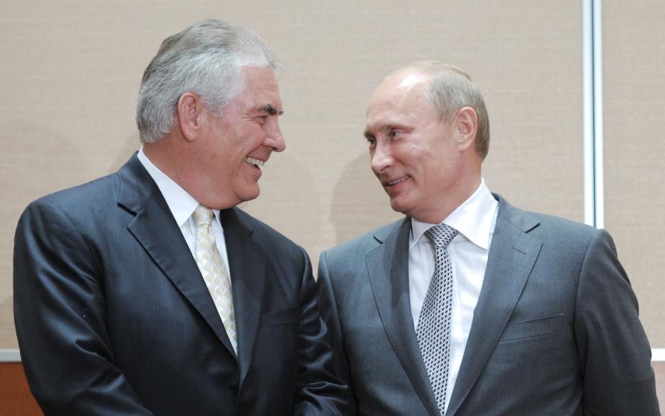 Russia's Prime Minister Vladimir Putin speaking with ExxonMobil President and Chief Executive Officer Rex Tillerson during the signing of a Rosneft-ExxonMobil strategic partnership agreement in Sochi on August 30, 2011 - Credit: ALEXEY DRUZHININ/AFP PHOTO