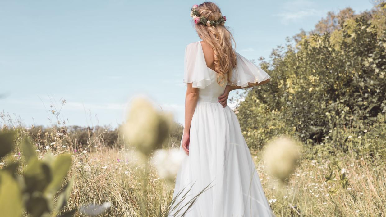 Bride in a field with her back to the camera