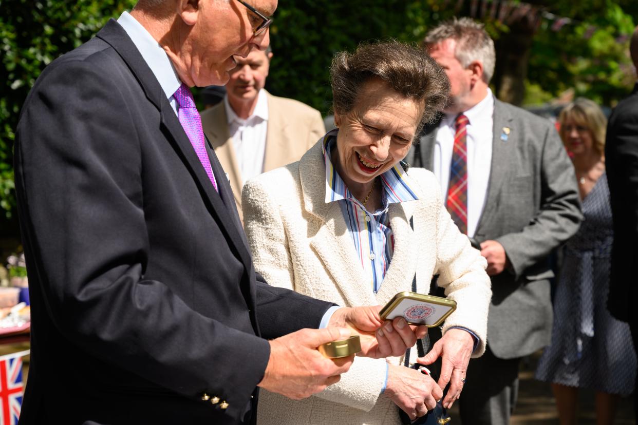 Princess Anne views commemorative tins of old coins before they are gifted to children as she visits a Coronation street party in Swindon (Getty)