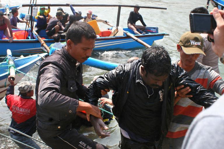 Rescuers assist survivors near Cidaun, West Java, in July 2013, after an Australia-bound boat carrying asylum-seekers sank off the Indonesian coast