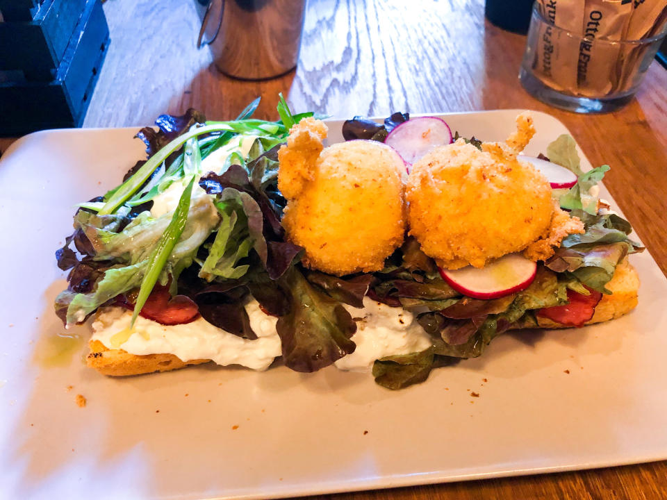 Traditional Zagreb breakfast at Otto & Frank. Bread with fried eggs, greens, and radish on top.