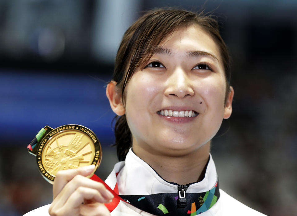 FILE - In this Aug. 24, 2018, file photo,  Japan's Rikako Ikee holds up her gold medal after winning the women's 50m freestyle final during the swimming competition at the 18th Asian Games in Jakarta, Indonesia. Ikee, the favorite for the 100-meter butterfly for the 2020 Tokyo Olympics, has been diagnosed with leukemia. Ikee said on her verified Twitter account Tuesday, Feb. 12, 2019, her illness surfaced when she got tests after returning from Australia not feeling well. (AP Photo/Lee Jin-man, File)