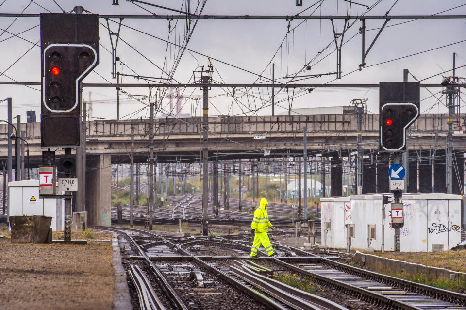 The lights show red as a man crosses the rails at Schaarbeek rail station in Brussels, Wednesday, Oct. 3, 2012. A 24-hour strike by Belgian rail workers on Wednesday paralyzed train traffic throughout Belgium and the international high-speed service to London and Paris. The strike, which started late Tuesday, reached its peak during the Wednesday morning rush hour when tens of thousands of commuters had to take to traffic-choked highways to get into the capital or work. (AP Photo/Geert Vanden Wijngaert)