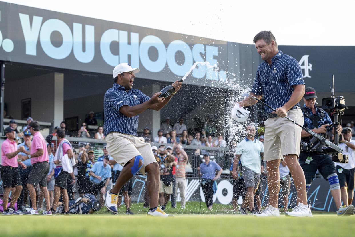 Captain Bryson DeChambeau of Crushers GC celebrates making his putt on the 18th green and the Crushers GC team win as Anirban Lahiri of Crushers GC sprays him with champagne after the finals of the LIV Golf Team Championship Miami at the Trump National Doral on Sunday, October 22, 2023 in Miami, Florida. (Photo by Charles Laberge/LIV Golf via AP)