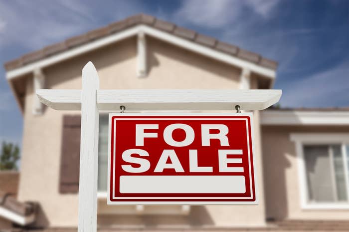 A "For Sale" sign in front of a house