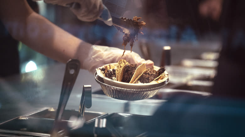 Employee serving food at Chipotle 