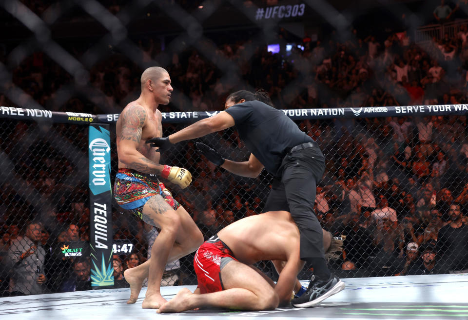 The referee moves in to protect Jiri Prochazka from light heavyweight champion Alex Pereira, left, during the UFC 303 mixed martial arts event Saturday, June 29, 2024, in Las Vegas. Pereira retained his title. (Steve Marcus/Las Vegas Sun via AP)