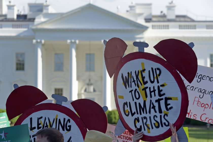 FILE- In this June 1, 2017 file photo, protesters gather outside the White House in Washington to protest President Donald Trump's decision to withdraw the Unites States from the Paris climate change accord. For more than two years President Trump has talked about pulling the United States out of the landmark Paris climate agreement. Starting Monday, he can finally do something about it. But the withdrawal process will take a year and doesn't become official until the day after the 2020 presidential election. And if someone other than Trump wins in 2020, the next president can get back in the deal in just 30 days. (AP Photo/Susan Walsh)