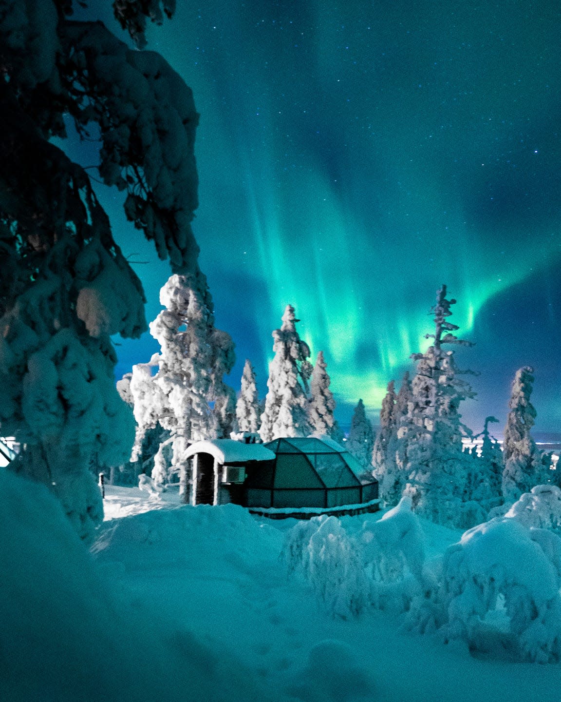 at finland’s levin iglut resort, travelers can curl up in bed under a glass dome to watch the northern lights