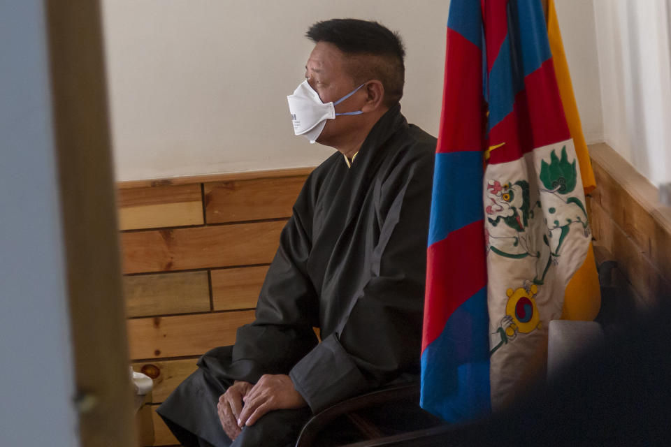 Penpa Tsering, the newly elected President of the Central Tibetan Administration, sits next to a Tibetan flag in the office of the Tibetan Supreme Justice Commissioner before taking oath of office in Dharmsala, India, Thursday, May 27, 2021. The new president of the Tibetan exile government said Thursday he was willing to reach out to the Chinese government to resolve their conflict, though the sides haven't had dialogue in the past decade. (AP Photo/Ashwini Bhatia)