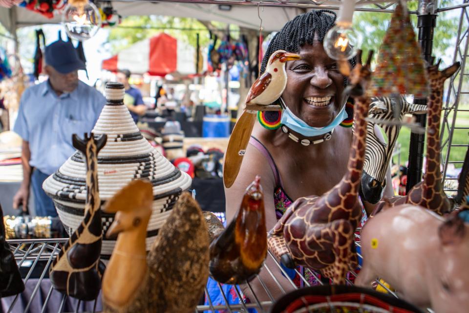Elizabeth Kizito, right, finishes setting up her booth during WorldFest at the Belvedere on Friday. Sept. 3, 2021