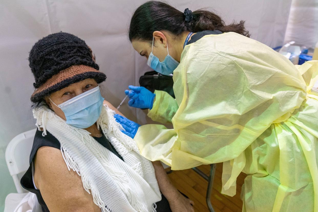 In this Jan. 31, 2021, photo, registered Nurse Rita Alba gives a patient the first dose of the coronavirus vaccine at a pop-up COVID-19 vaccination site at the Bronx River Community Center in the Bronx borough of New York. The deadliest month of the coronavirus outbreak in the U.S. drew to a close with certain signs of progress. COVID-19 cases and hospitalizations are trending downward, while vaccinations are picking up speed.