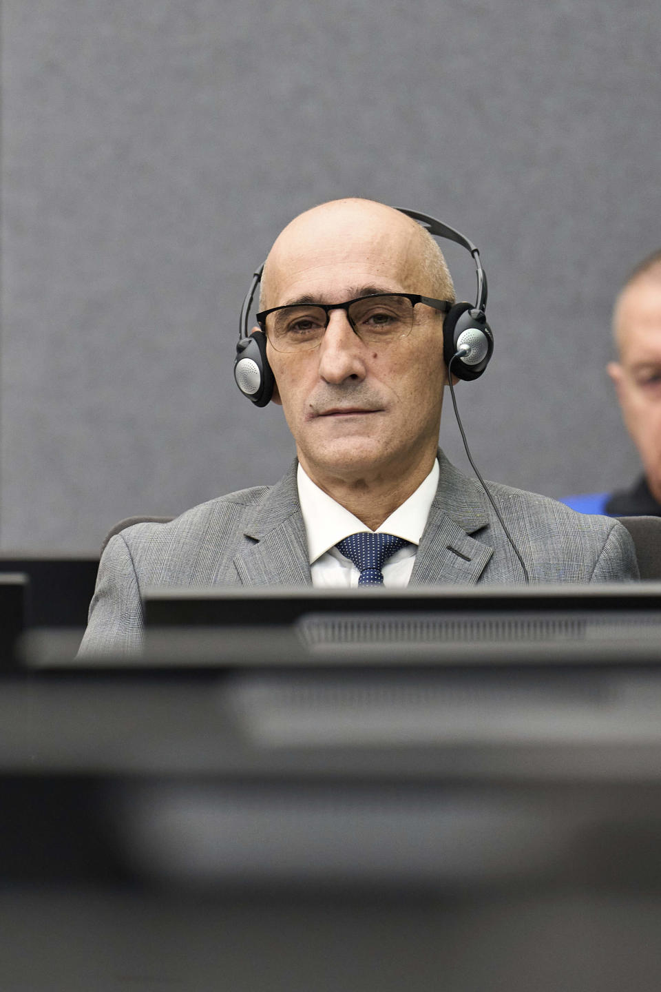 Salih Mustafa sits at a special Kosovo court in The Hague, Netherlands, Thursday, Dec. 14, 2023. Appeals judges at a special Kosovo court in the Netherlands were ruling Thursday in case of a former commander in the Kosovo Liberation Army who was convicted a year ago for arbitrarily detaining and torturing prisoners and murdering one of them during a late 1990s war for Kosovo’s independence. The commander, Salih Mustafa, was convicted a year ago and sentenced to 26 years’ imprisonment for the crimes committed at a KLA compound in Zllash, Kosovo, in April 1999. He was acquitted of one charge of mistreating detainees who were perceived as supporters of Serbia. (AP Photo/Phil Nijhuis, Pool)