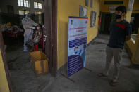 An Indian health worker takes a nasal swab sample of a woman to test for COVID-19 as a man waits for his turn in Gauhati, India, Sunday, Sept. 6, 2020. India's coronavirus cases have crossed 4 million, leading the world in new infections and deepening misery in the country's vast hinterlands where surges have crippled the underfunded health care system. (AP Photo/Anupam Nath)