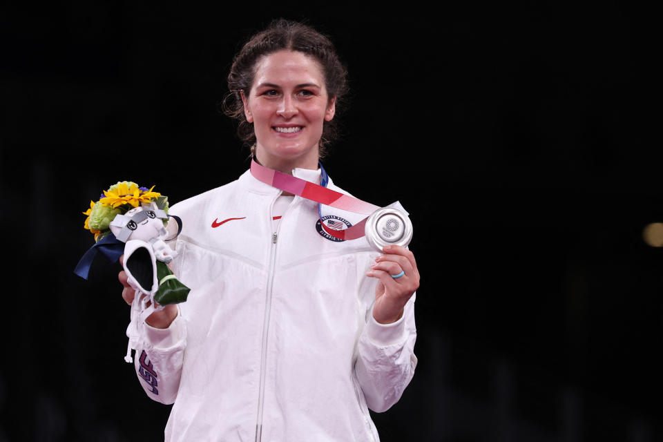 Gray posing on the podium with her silver medal and flowers