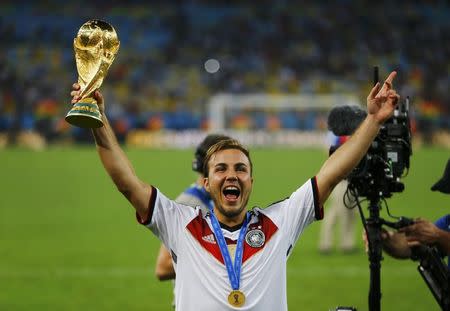 Germany's Mario Goetze holds up the World Cup trophy as he celebrates their 2014 World Cup final win against Argentina at the Maracana stadium in Rio de Janeiro July 13, 2014. REUTERS/Damir Sagolj