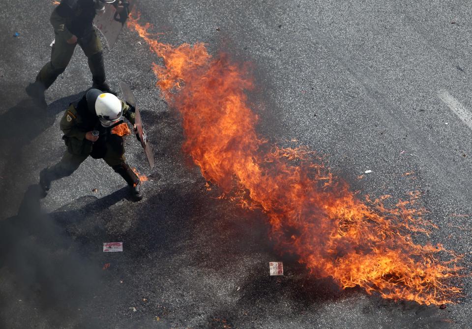 Riot police try to avoid a petrol bomb in Athens, during a 24-hour nationwide general strike on Thursday, Oct. 18, 2012. Greece was facing its second general strike in a month Thursday as workers protested over another batch of austerity measures that are designed to prevent the bankruptcy of the country. (AP Photo/Thanassis Stavrakis)