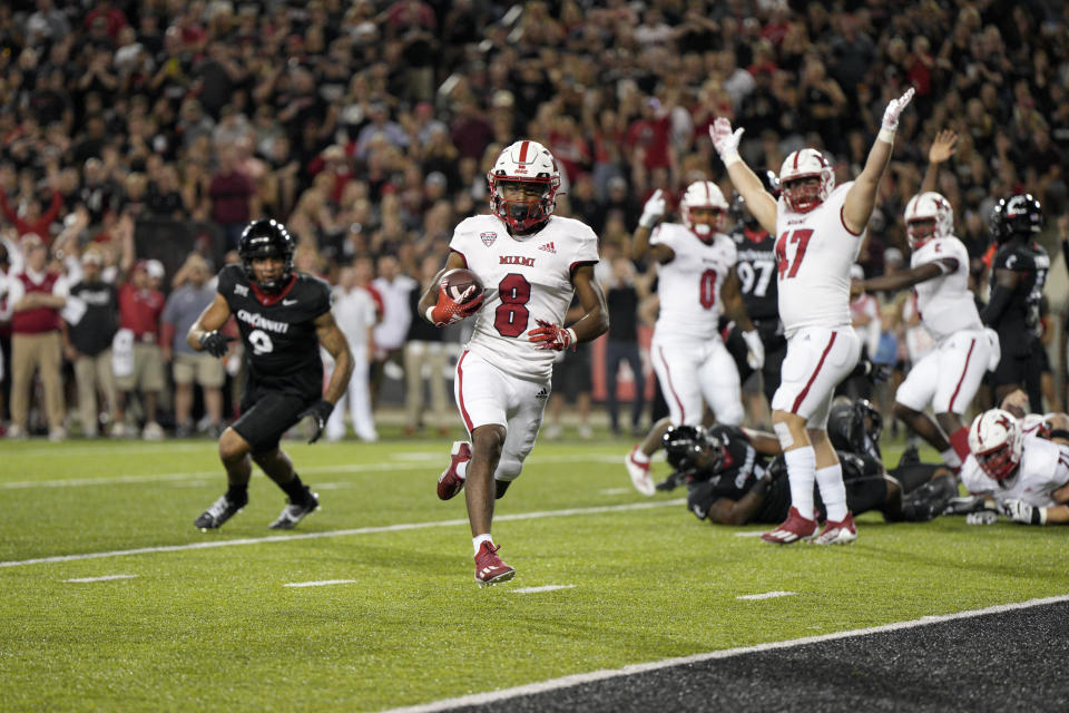 Miami (Ohio) running back Kevin Davis (8) scores during the second half of an NCAA college football game against Cincinnati, Saturday, Sept. 16, 2023, in Cincinnati. (AP Photo/Jeff Dean)