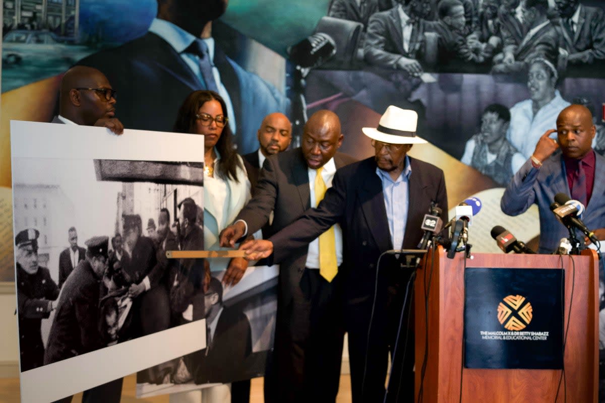 Mustafa Hassan points to himself in a photo from the day Malcolm X was assassinated (Ariana Baio / The Independent)