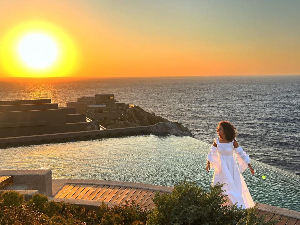 latifah taking a photo in front of a hotel pool at sunset