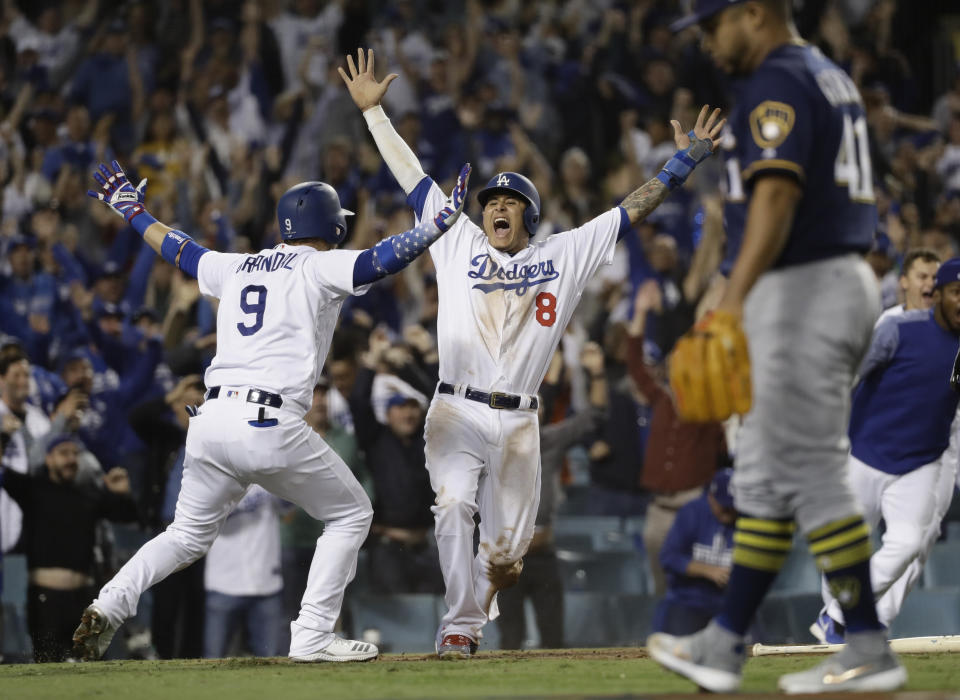 ARCHIVO - En esta foto de archivo del 16 de octubre de 2018, Manny Machado (8), de los Dodgers de Los Ángeles, reacciona tras anotar en un imparable de Cody Bellinger durante la 13ra entrada del cuarto juego de la Serie de Campeonato de la Liga Nacional contra los Cerveceros de Milwaukee, en Los Ángeles. (AP Foto/Matt Slocum, Archivo)