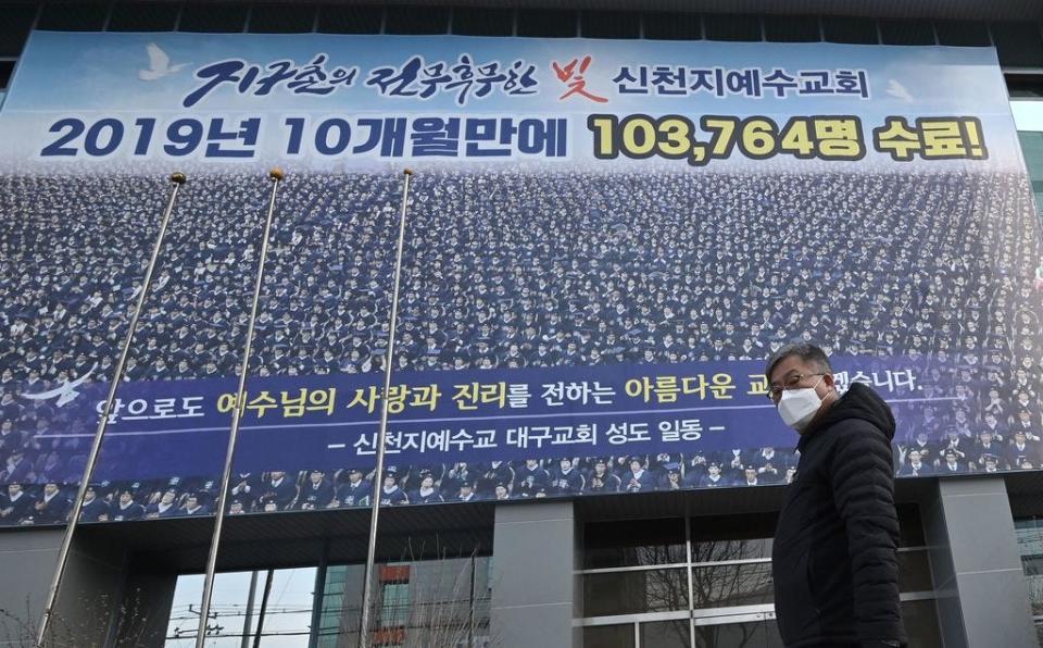 A man wearing a face mask walks in front of the Daegu branch of the Shincheonji Church of Jesus in the southeastern city of Daegu on Feb. 21, 2020 as more than 80 members of Shincheonji have now been infected with the COVID-19 coronavirus.