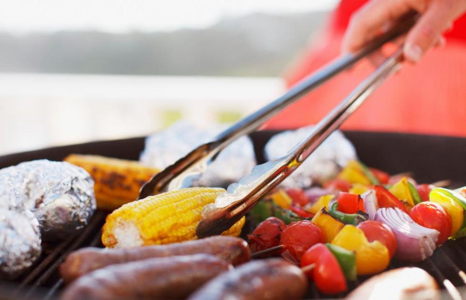 Close up of man grilling food on barbecue