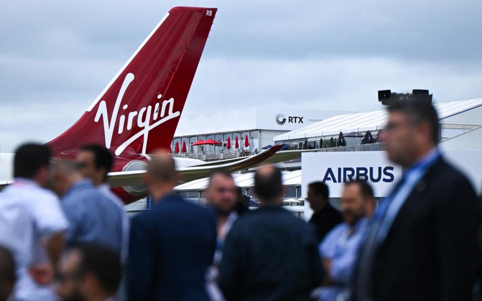 Visitors near an Airbus A330-900 on the second day of the Farnborough Airshow today