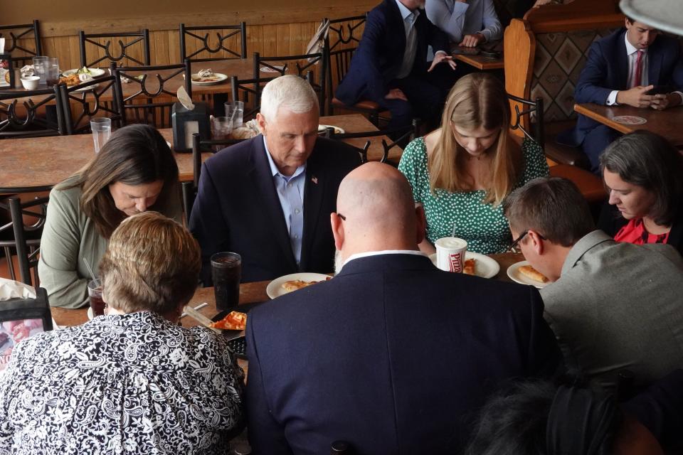 Republican presidential candidate former Vice President Mike Pence prays before eating at a Pizza Ranch restaurant on June 08, 2023 in Waukee, Iowa.