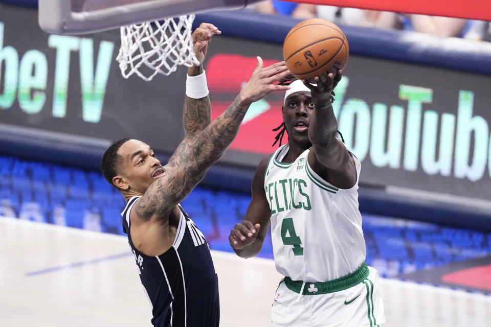 Boston Celtics guard Jrue Holiday (4) shoots against Dallas Mavericks forward P.J. Washington, left, during the first half in Game 4 of the NBA basketball finals, Friday, June 14, 2024, in Dallas. (AP Photo/Sam Hodde)