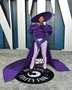 <p>The Oscars performer wore a purple off-the-shoulder top with a cape to the star-studded party. The colour purple has longer been associated with royalty and power.<br>The outfit - created by Christian Siriano - featured feathers on the bust and was teamed with a pair of purple elbow-length gloves, a pair of lilac-coloured cigarette trousers, black heeled boots, a purple Sarah Sokol Millinery wide-brimmed hat and a ThesePinkLips handbag.</p>