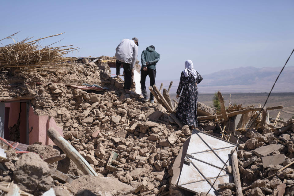 People inspect the damage caused by the earthquake in the village of Tafeghaghte, near Marrakech, Morocco, Monday, Sept. 11, 2023. Rescue crews expanded their efforts on Monday as the earthquake's death toll continued to climb to more than 2,400 and displaced people worried about where to find shelter. (AP Photo/Mosa'ab Elshamy)