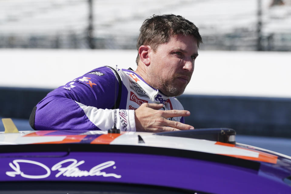 Denny Hamlin climbs out of his car during qualifications for the NASCAR Cup Series auto race at Indianapolis Motor Speedway, Saturday, July 30, 2022, in Indianapolis. (AP Photo/Darron Cummings)