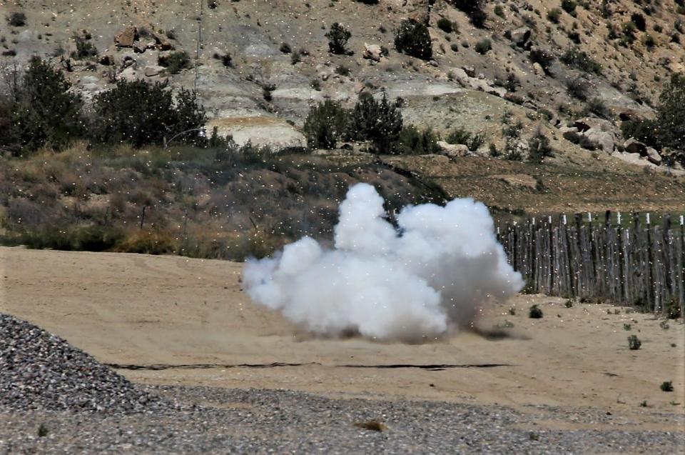 Debris flies outward after a 3-inch shell lit by Tommy Bolack detonates on his B-Square Ranch in Farmington.