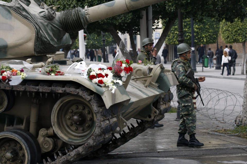 FILE - In this Tuesday, Jan. 18, 2011 file photo, flowers are displayed on a tank as soldiers guard the center of Tunis. Tunisia’s president on Thursday March 6, 2014 lifted the state of emergency that has been in place since the outbreak of a popular revolution three years ago, and a top military chief said soldiers stationed in some of the country’s most sensitive areas will return to their barracks. (AP Photo/Christophe Ena, File)