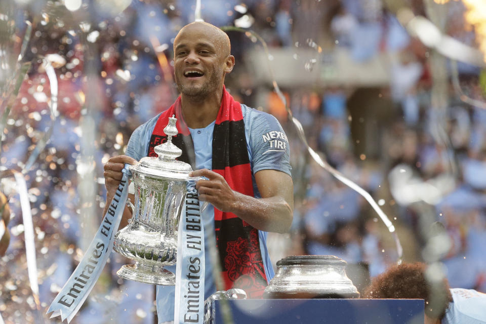 Manchester City's team captain Vincent Kompany lifts the trophy after winning the English FA Cup Final soccer match between Manchester City and Watford at Wembley stadium in London, Saturday, May 18, 2019. Manchester City won 6-0. (AP Photo/Tim Ireland)