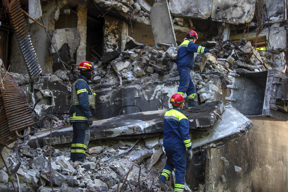 Ukrainian emergency service personnel work outside a damaged building following shelling, in Kharkiv, Ukraine, Saturday, June 4, 2022. (AP Photo/Sofiia Bobok)