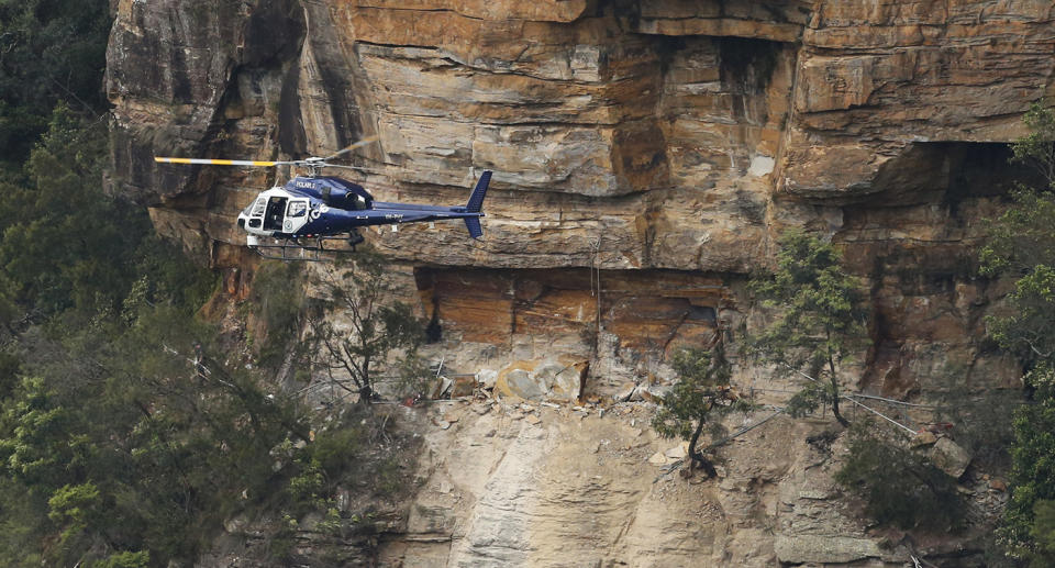 A man has died and two others were trapped following a landslide in the Blue Mountains.